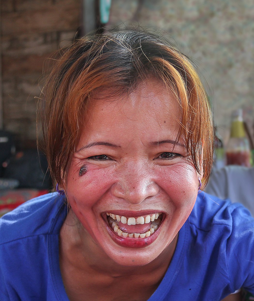 Woman laughing, looking at viewer