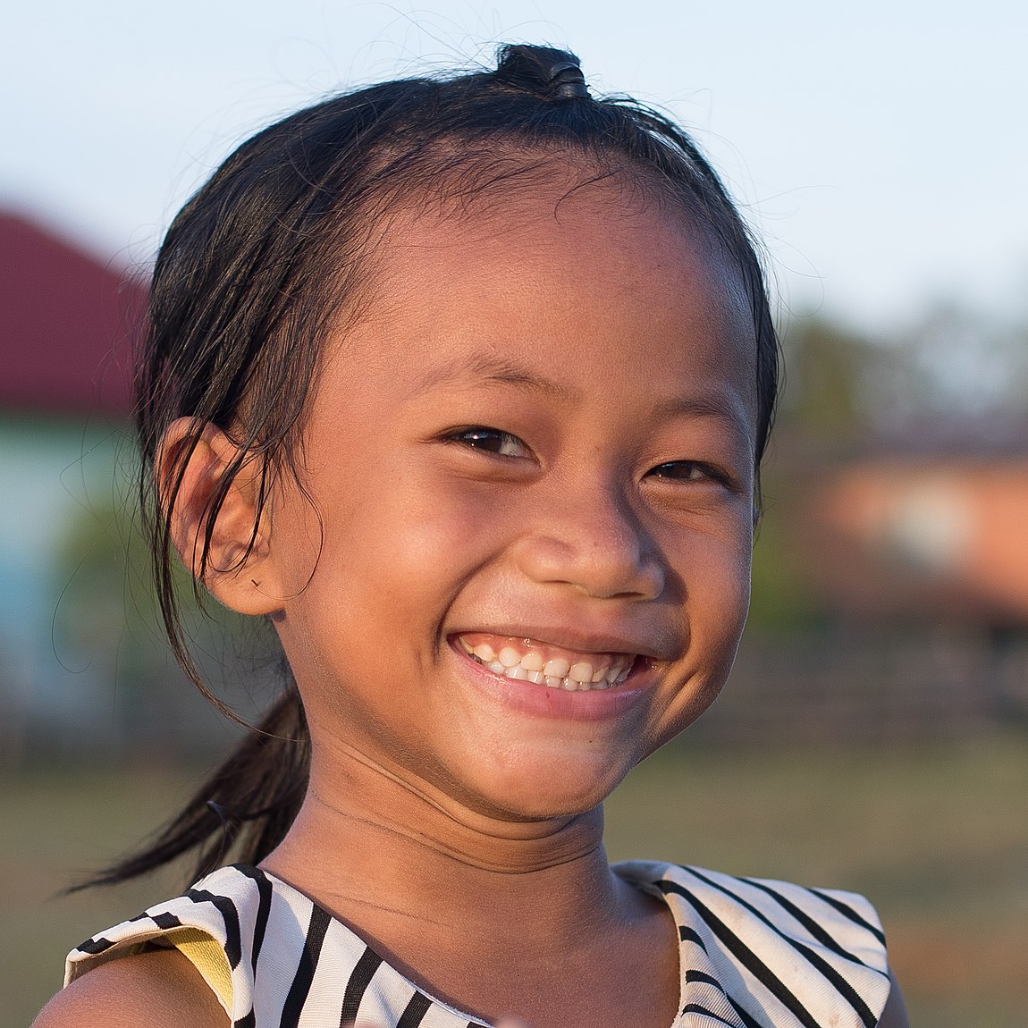 Smiling young girl with deciduous teeth, in Don Som, Laos