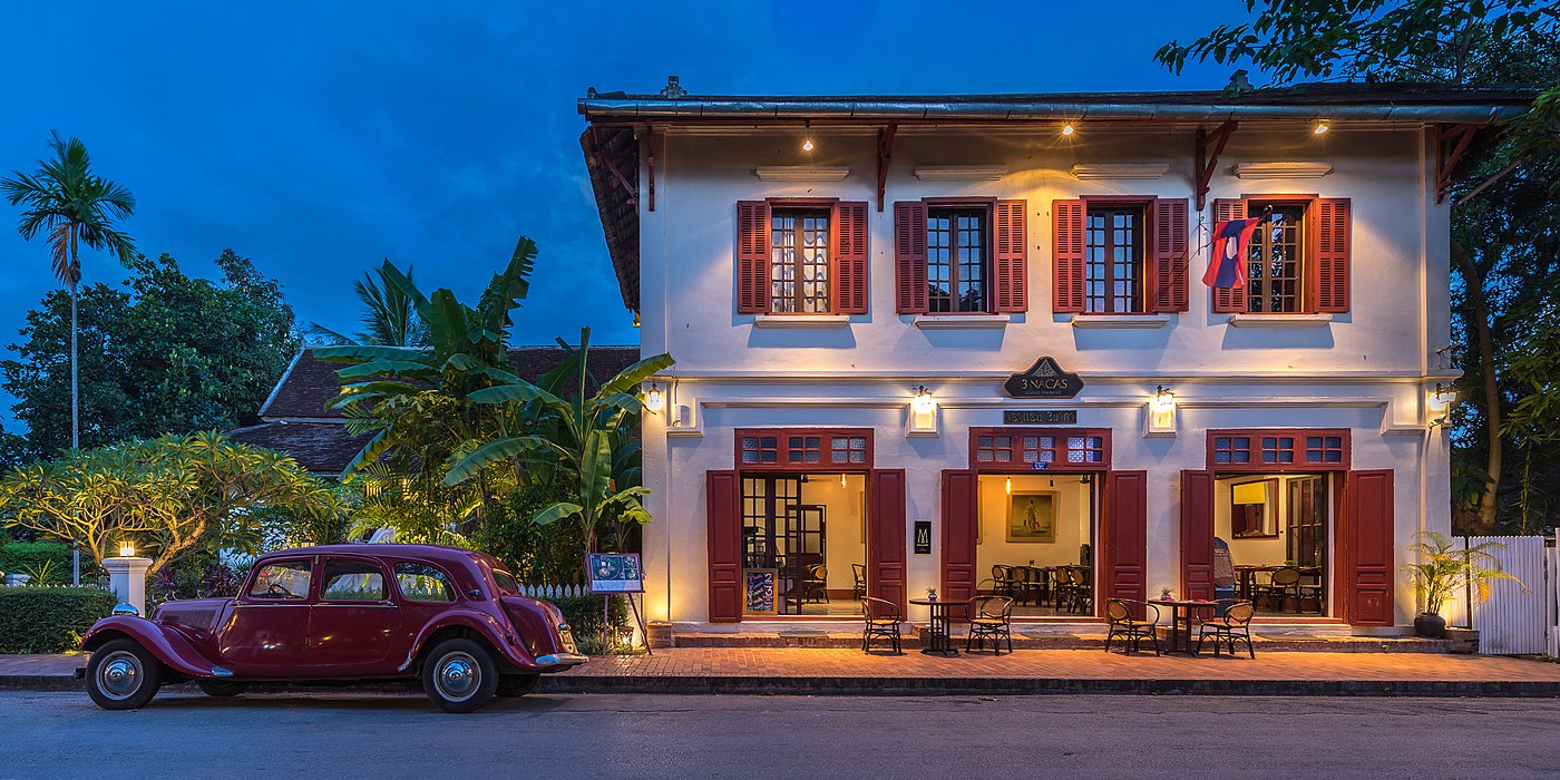 Hotel 3 Nagas with an old red Citroën Model 11 Family version (1952) at blue hour in Luang Prabang