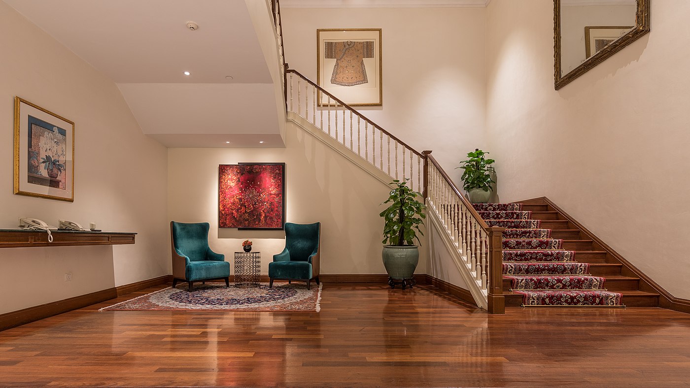 Escalier et salon avec deux fauteuils sur un parquet brillant à l'hôtel InterContinental, Singapour