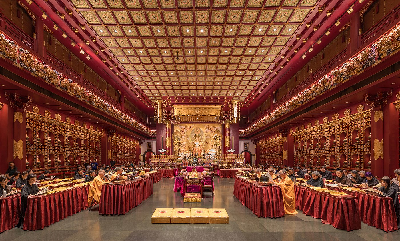 Moines et nonnes priant dans le Buddha Tooth Relic Temple de Singapour