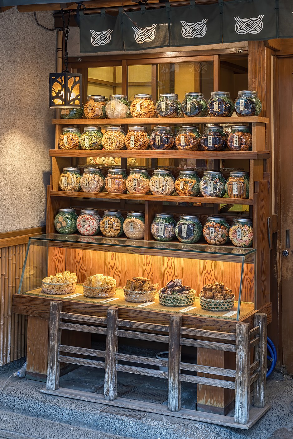 Illuminated wooden shelf with many glass jars